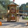Parco giochi con scivoli gialli e torrette su sabbia.