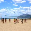 Gruppo che gioca a pallavolo su spiaggia.