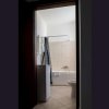 Bagno con vasca, tende e lavatrice, piastrelle beige.