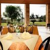 Tavoli apparecchiati in un ristorante all'aperto con vista sul giardino.