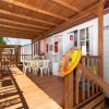 Veranda con tavolo, sedie e salvagente appeso alla porta.