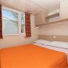 Camera con letto matrimoniale e copriletto arancione.