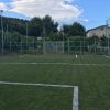 Campo da calcio recintato con erba verde.
