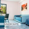 Junior suite con divano letto, scrivania e finestra panoramica.