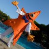 Persona in costume arancione a forma di stella marina vicino a una piscina all'aperto.