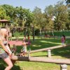 Bambini che giocano in un parco giochi con altalene e altalene a bilico.