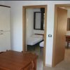 Interno di un appartamento con cucina e porta aperta verso una camera.