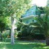 Edificio verde circondato da alberi e piante.