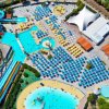 Veduta aerea di un parco acquatico con scivoli e piscine azzurre.